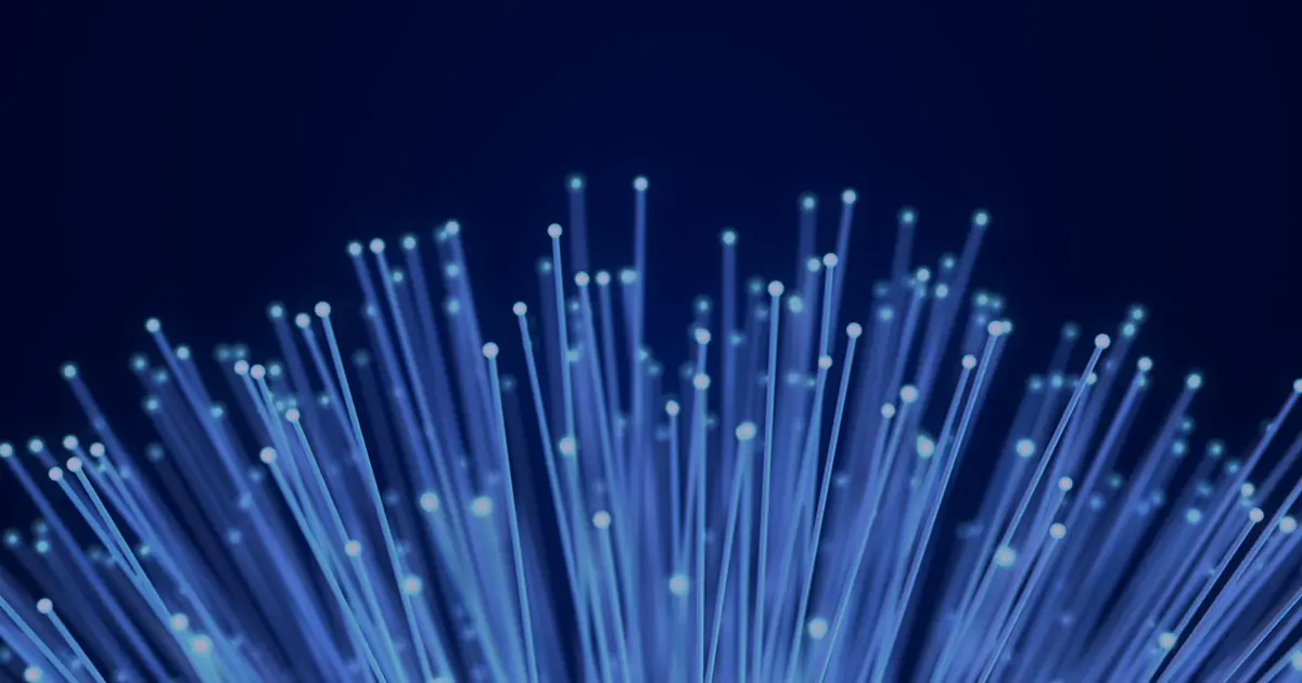 Abstract blue fiber-optic strands with glowing endpoints extending upward against a dark background, representing connectivity, data transmission, and digital infrastructure