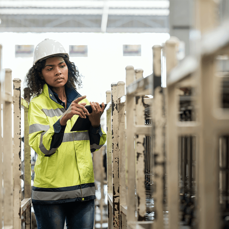 woman taking notes in manufacturing plant