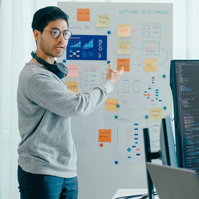 man pointing to a board with data and notes