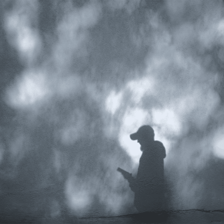 person in a baseball cap looking at phone