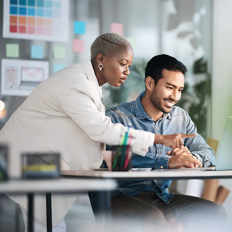 co workers gathered around a laptop