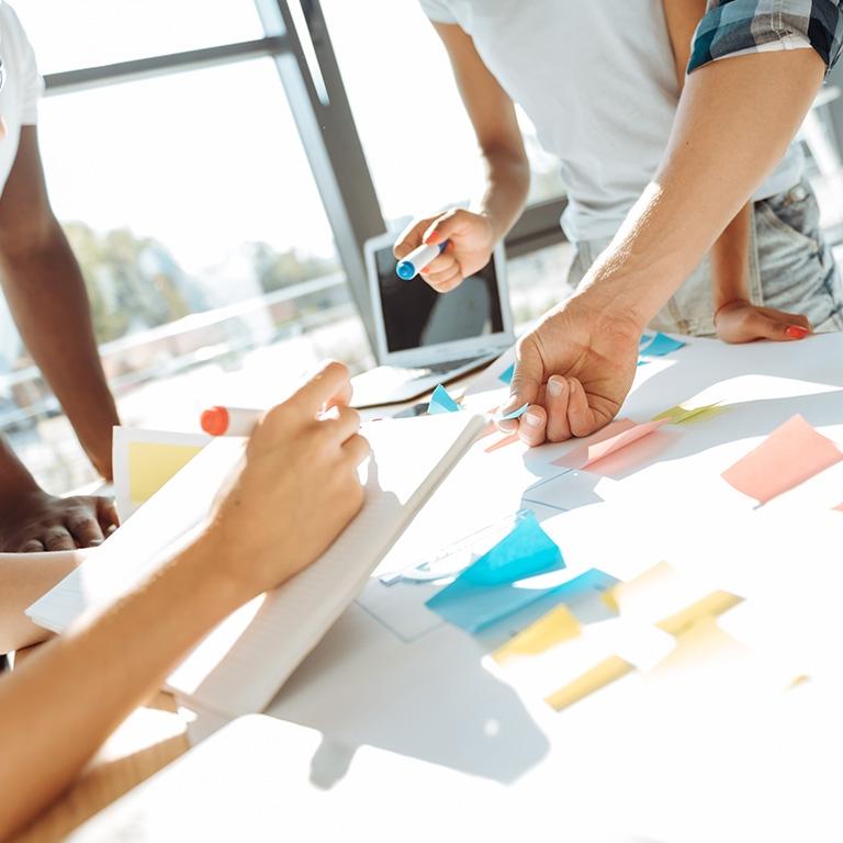 hands holding post-it notes and writing with markets