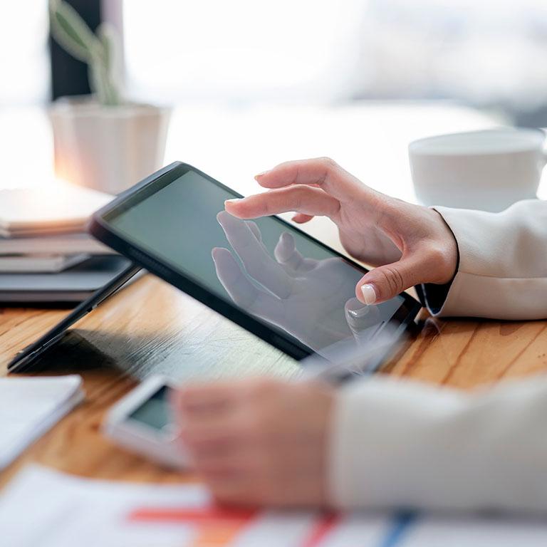 close-up of a person hands interacting with tablet in a coffee shop