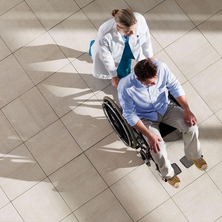 healthcare worker pushing someone in a wheelchair