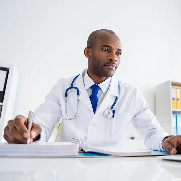 healthcare worker writing on stack of papers