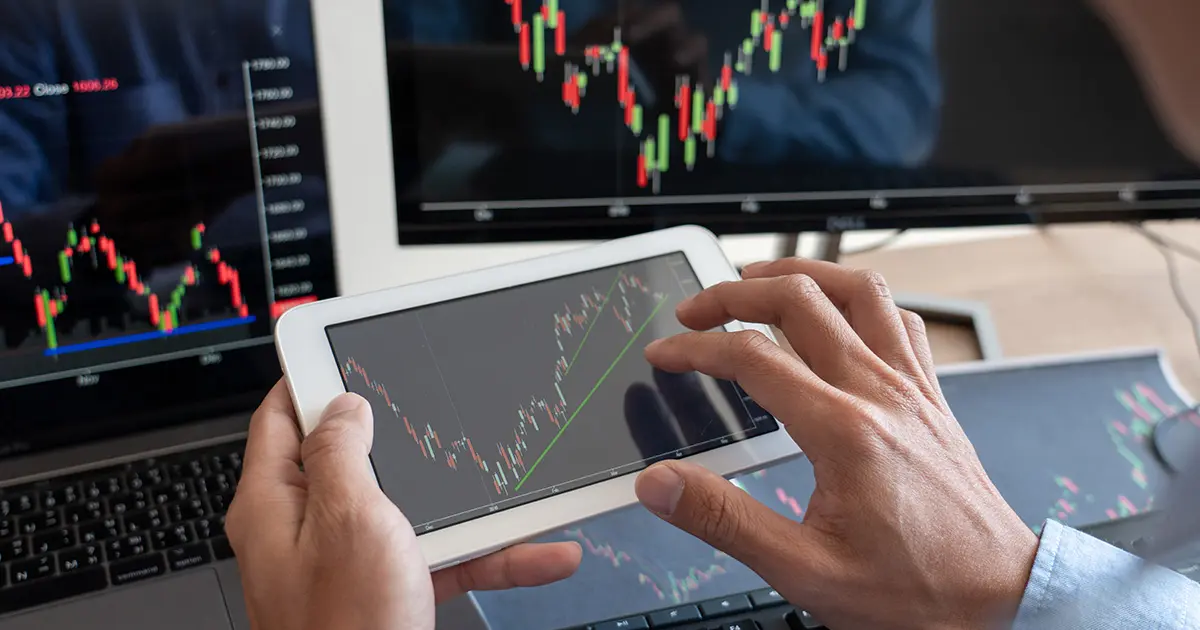 tablet and monitor screens displaying charts and graphs