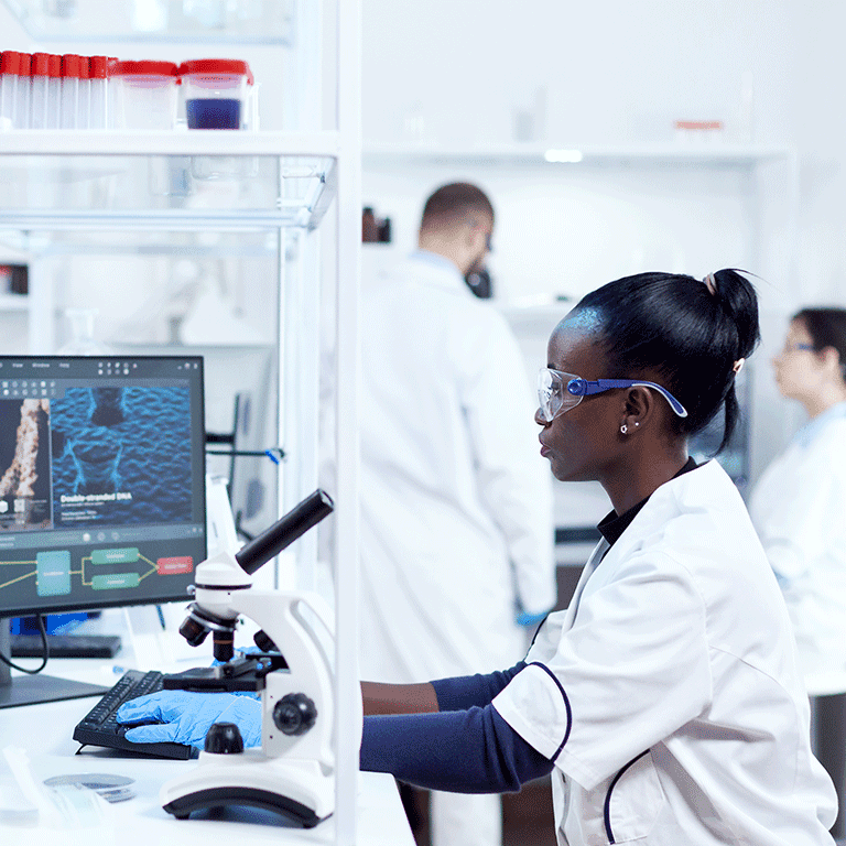 woman in goggles looking at microscope