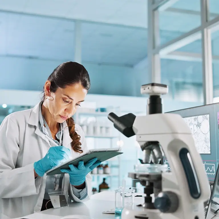 female working in a lap writing down notes on her clip board
