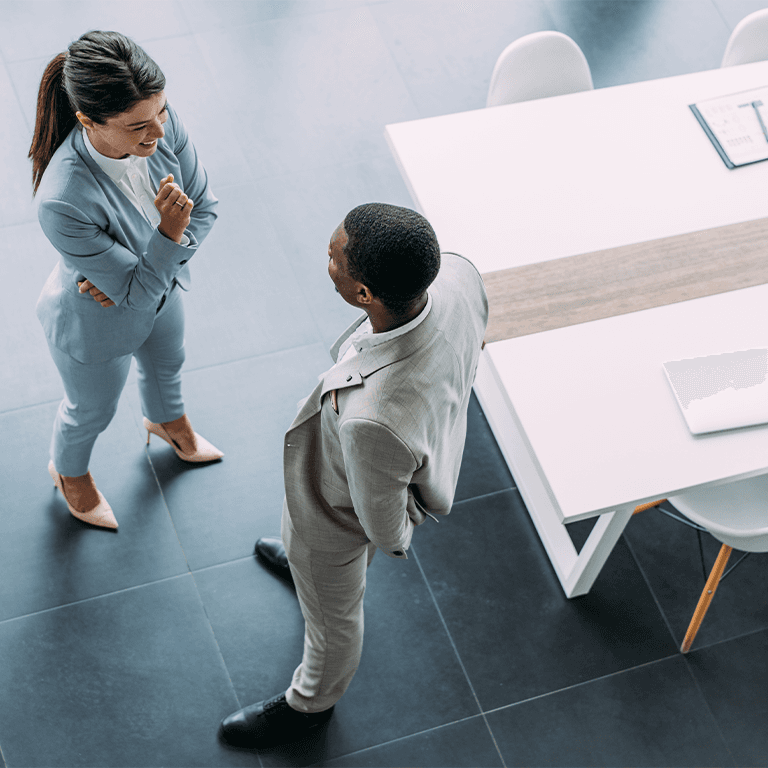 co-workers talking next to a long table