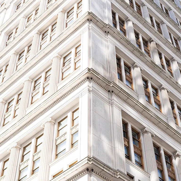 zoomed in photo of white building architecture and windows