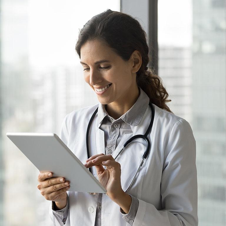female doctor interacting with tablet wearing a white coat