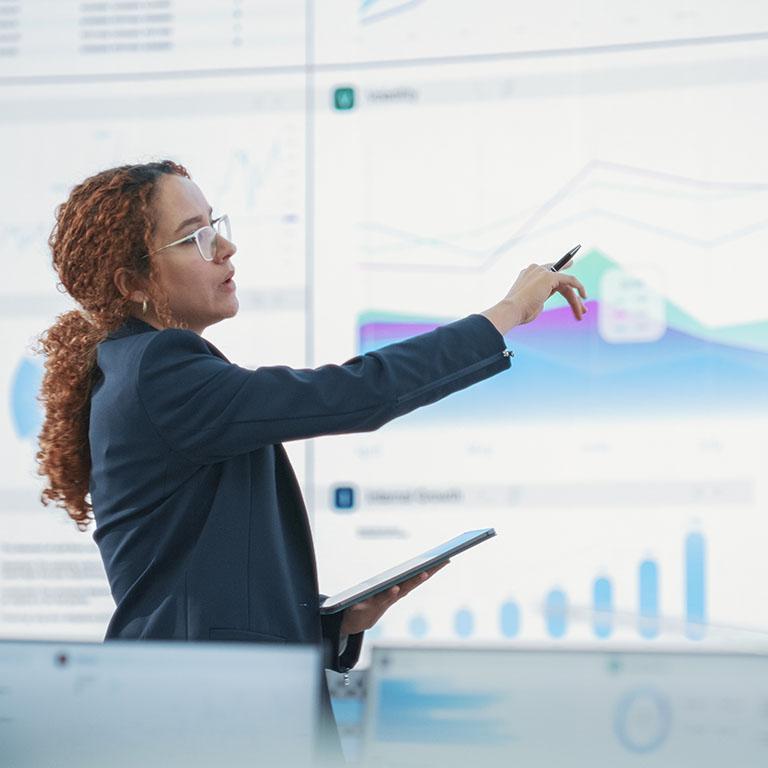 woman working on a data room around screen with data charts
