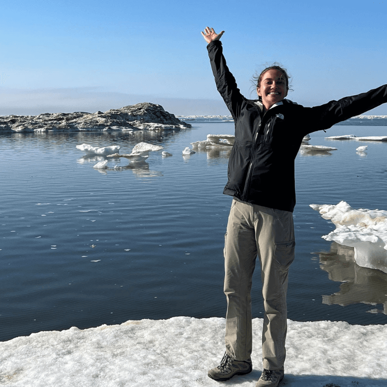 Woman on sheet of ice in body of water