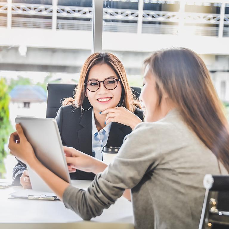 two women looking at a tablet