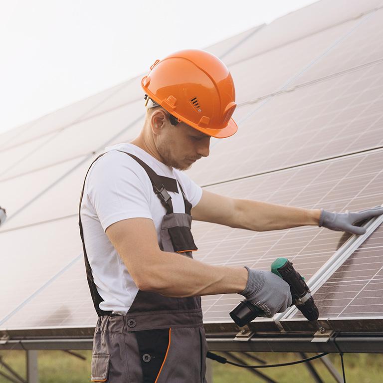 man in hard hat working on solar panels