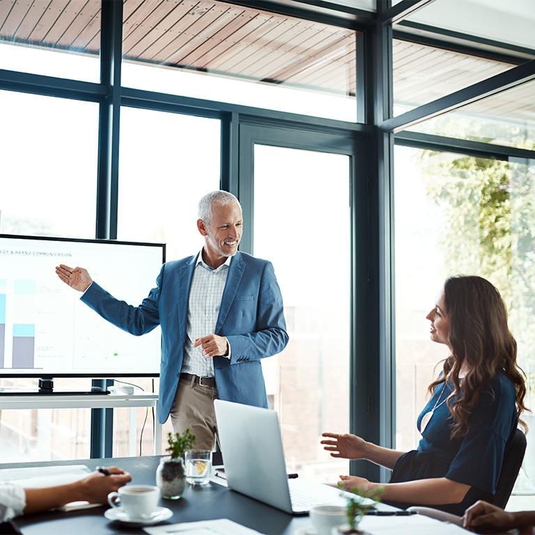 man presenting in front of large screen