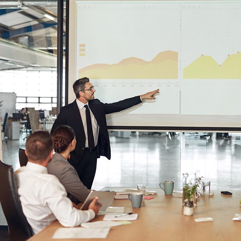man pointing at graphs on a screen