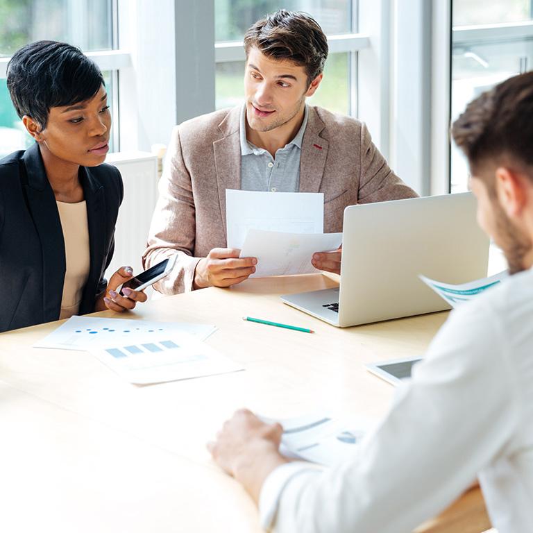 people at a table with papers and laptops