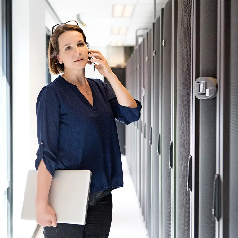 woman on a phone in front of servers