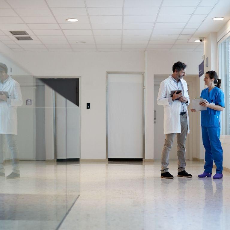 two healthcare workers talking in a hallway
