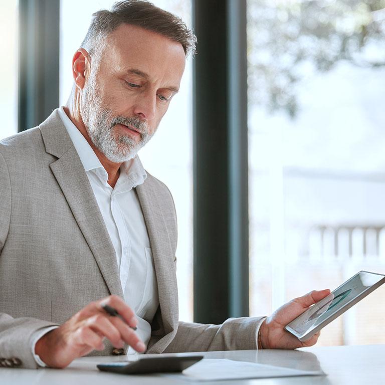 a professional man using a tablet and a phone