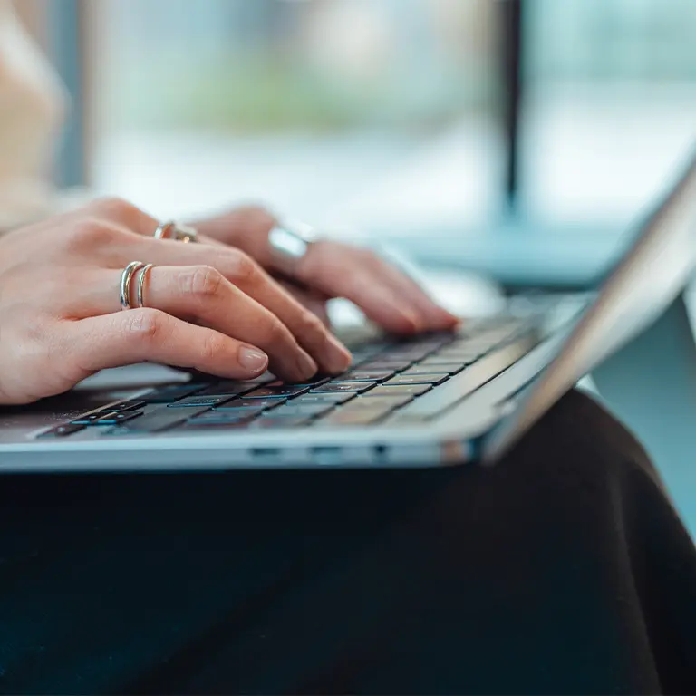 fingers typing at a laptop