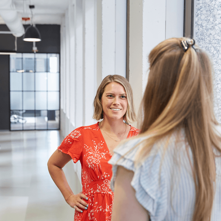 Women speaking in a hallway