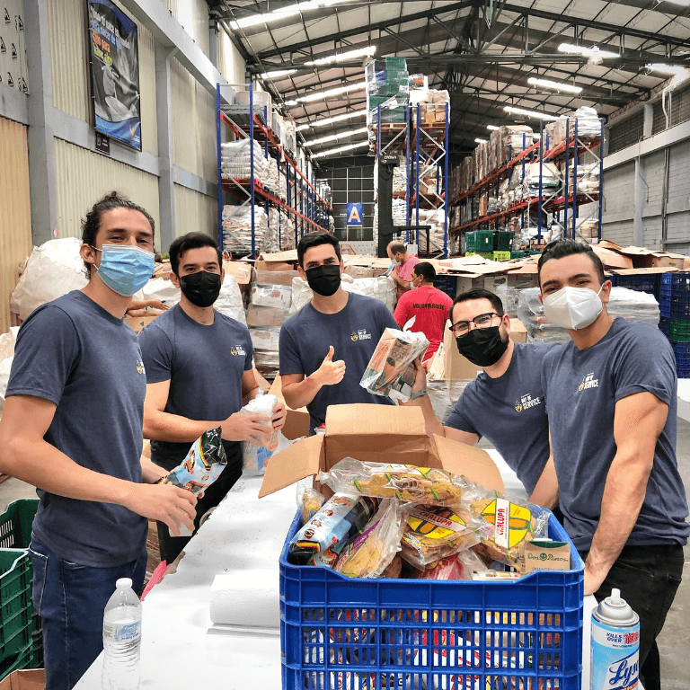 A group of men with masks on loading boxes
