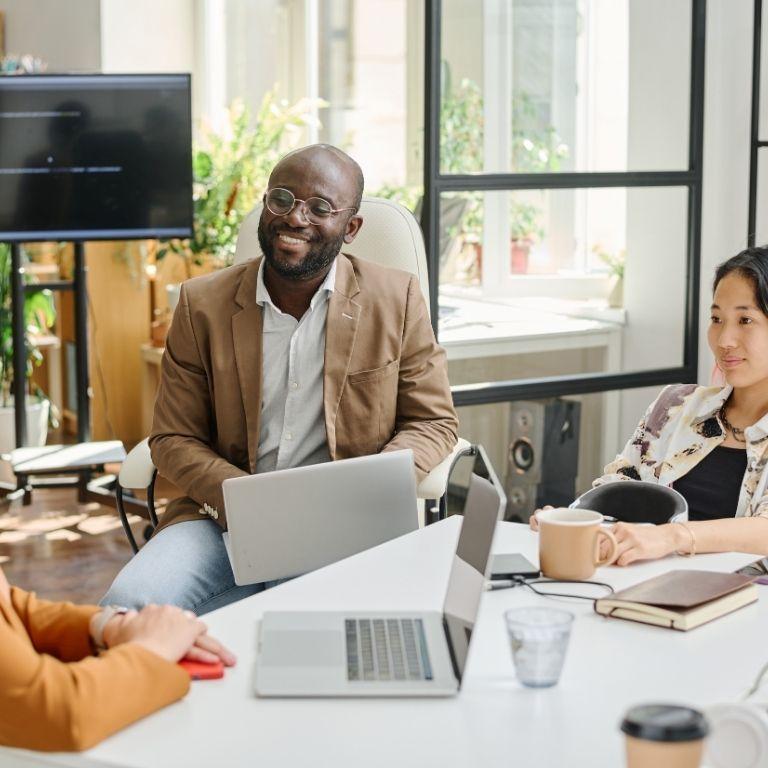 people with laptops around a table
