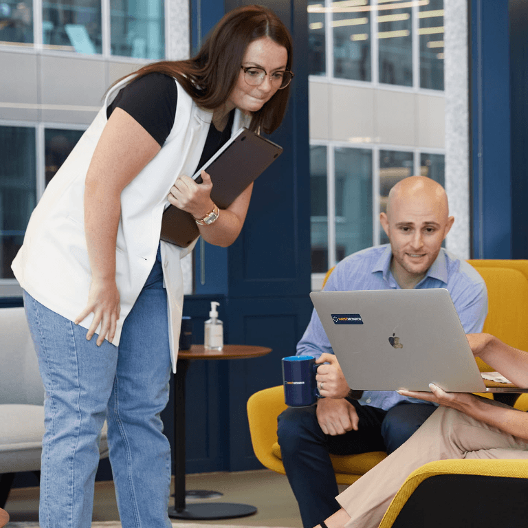 Coworkers looking at a laptop