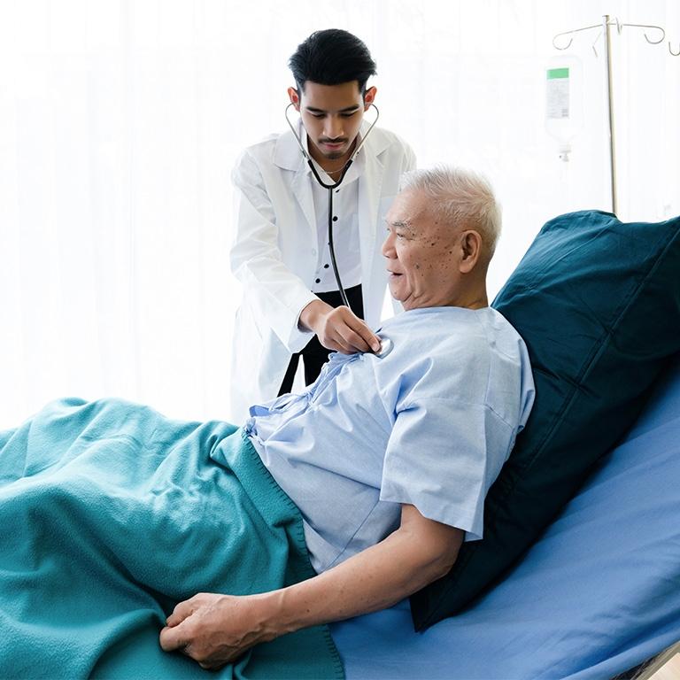 healthcare worker holding a stethoscope to a patient's chest