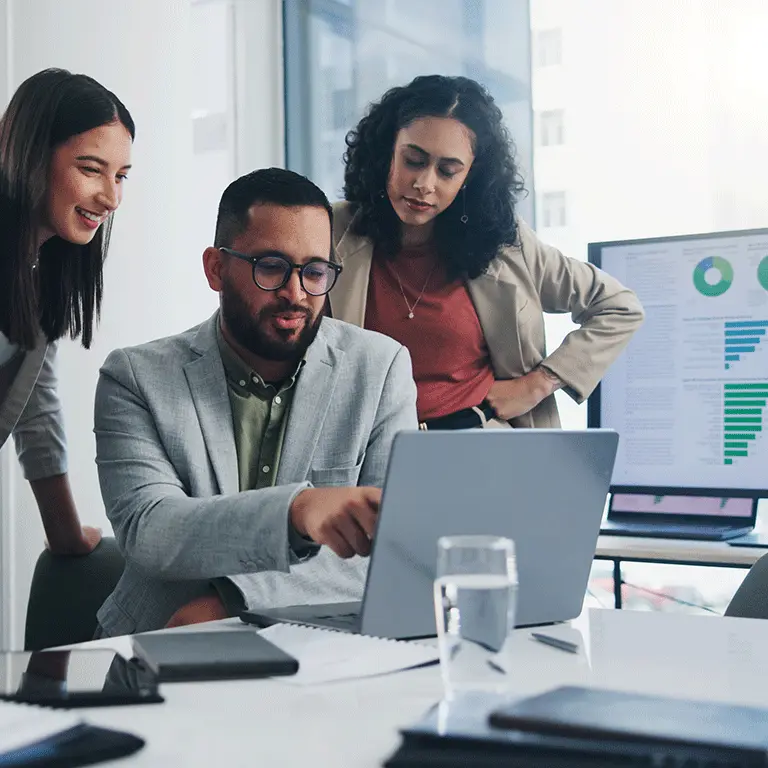 co workers gathered around a laptop