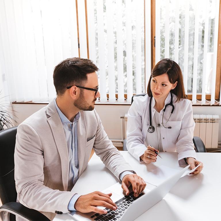 two people talking at a desk