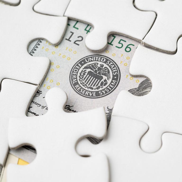 close-up of a white puzzle with a missing piece where part of the US is visible