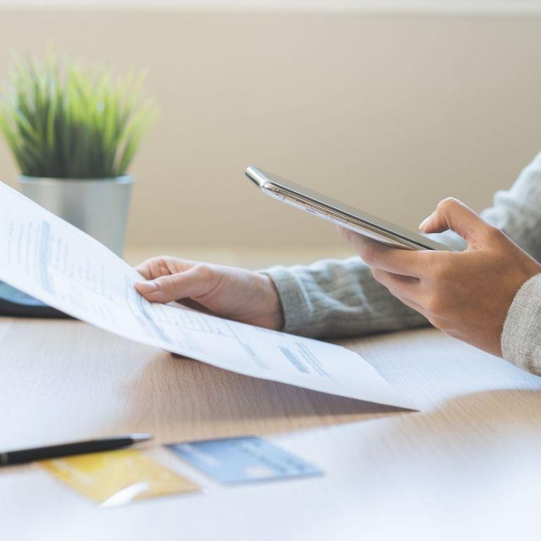 hands holding smartphone and paper