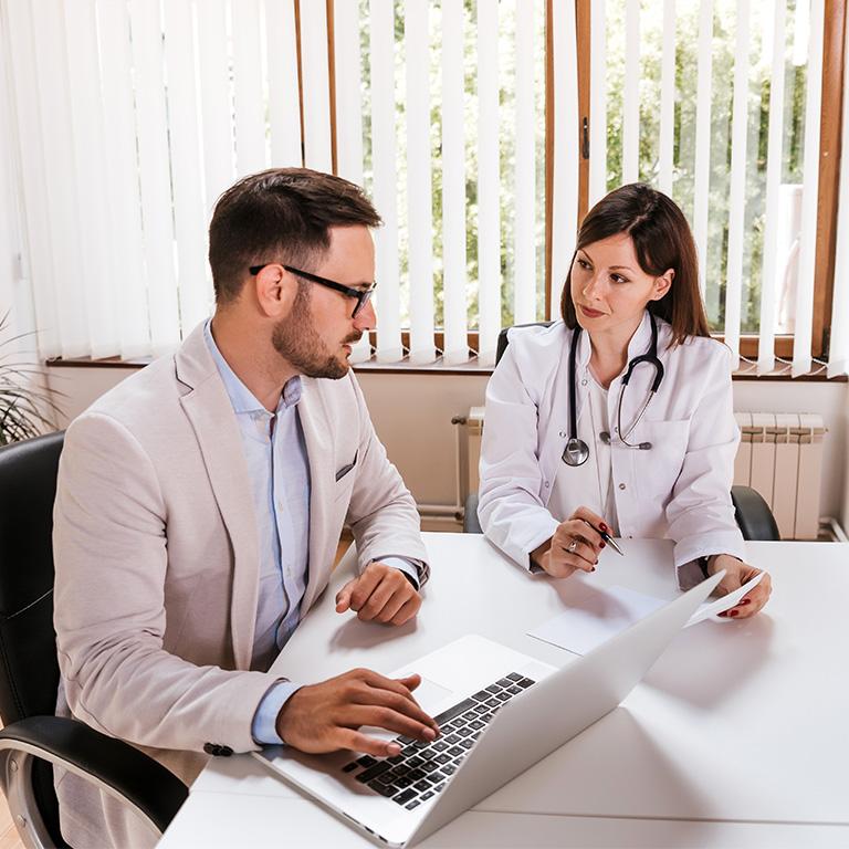 doctor talking to a man with a laptop