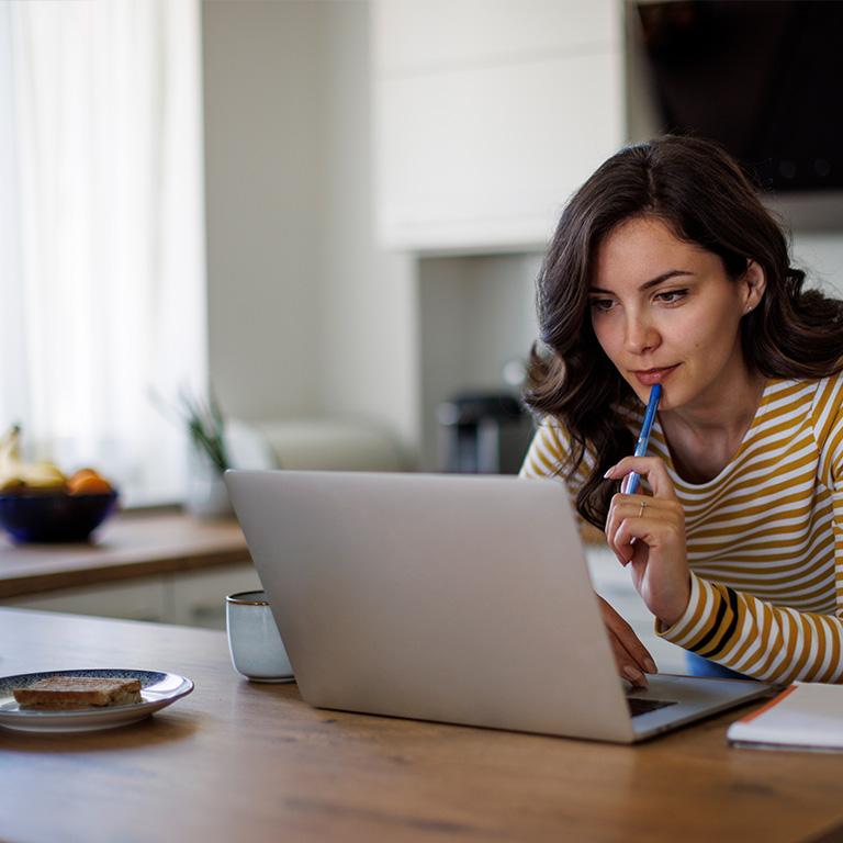 woman in her kitchen working on her laptop