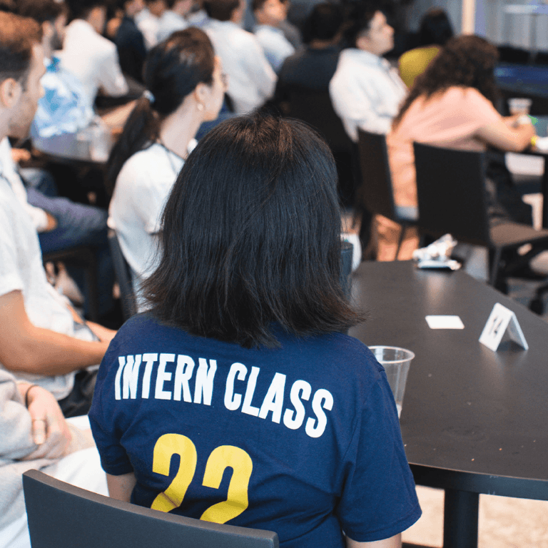Back of a woman wearing an "intern class" T Shirt